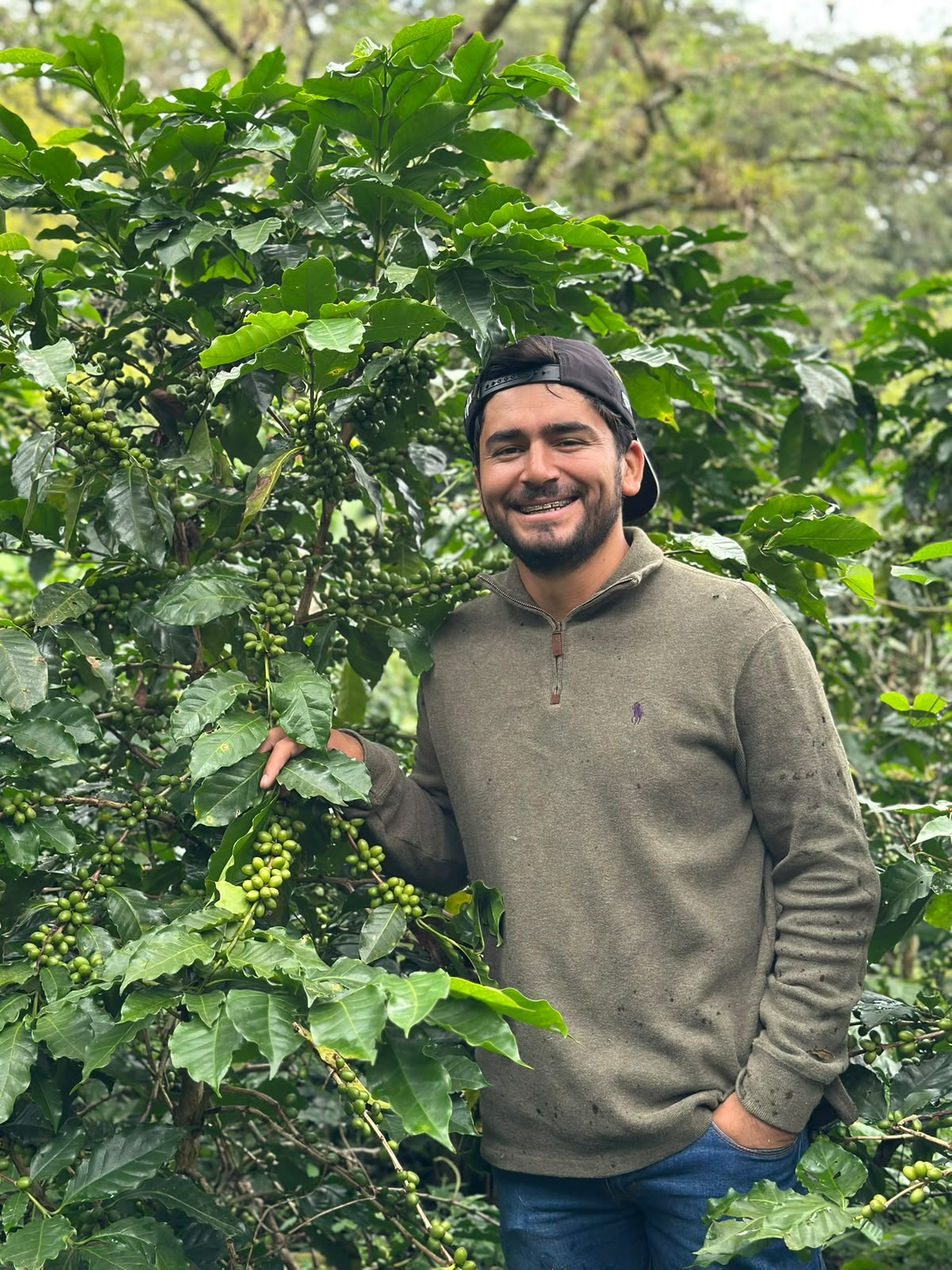 Bryan Bautista the producer of Apex Honduran coffee by Higher Grounds Trading Co standing by some coffee plants his farm in Honduras