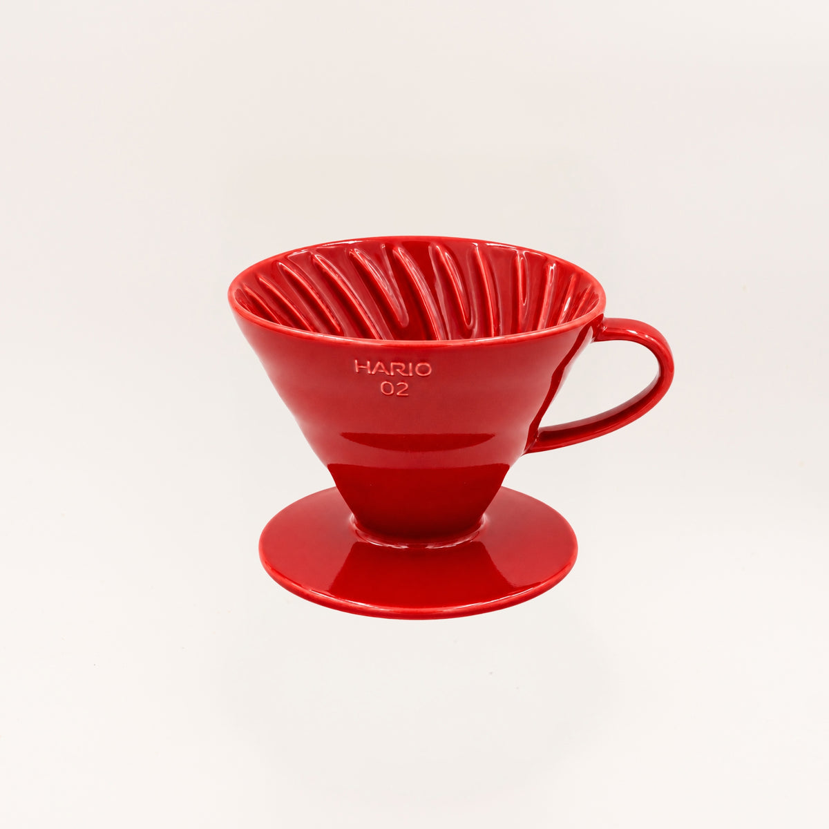A bright red ceramic pour-over coffee dripper by HARIO, model 02, shown on a clean white background.